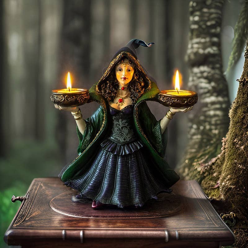 The Witches' Quest enchanted witch statue holding two tea light candles, wearing a green and purple gown in a forest.