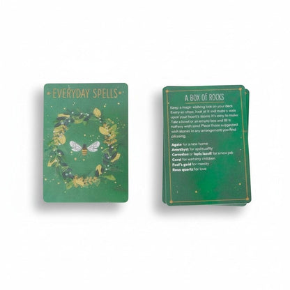 The Witches' Quest Everyday Spells deck featuring green botanical cards with a bee illustration and spell instructions.
