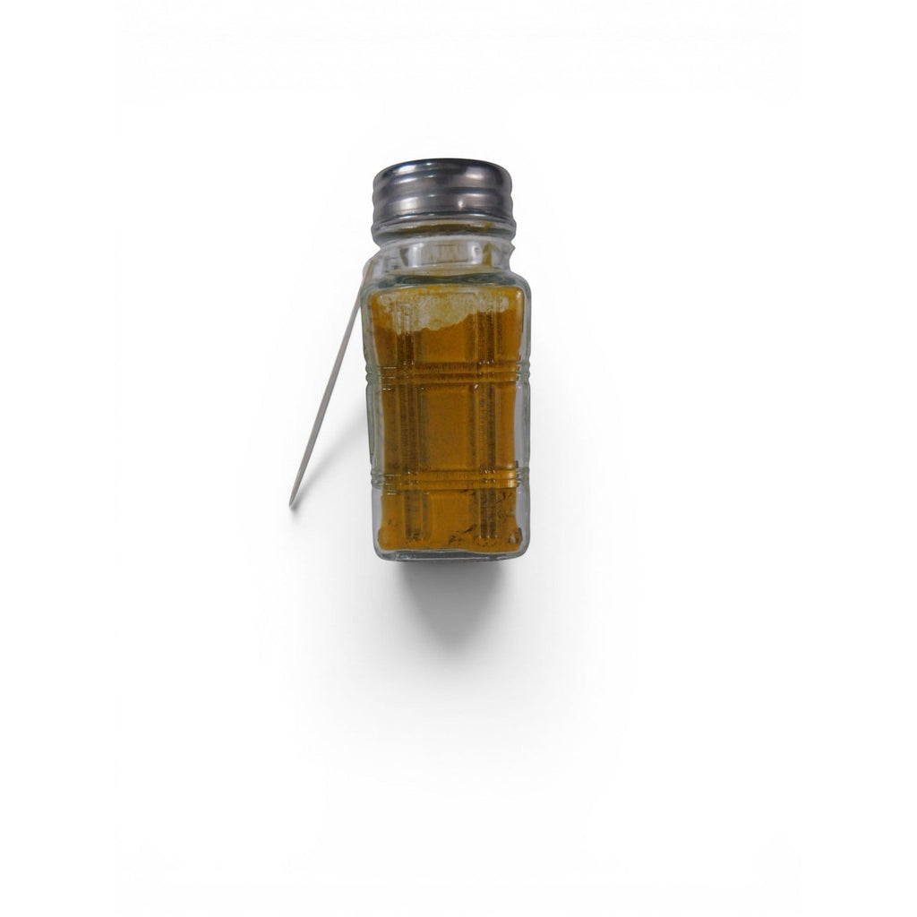 The Witches' Quest Ash & Sea Gold Dust ritual blend in a clear glass shaker bottle with a metal lid and hanging tag.