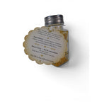 The Witches' Quest Gold Dust Money Spell Refresher in a clear glass shaker bottle with a decorative ritual label