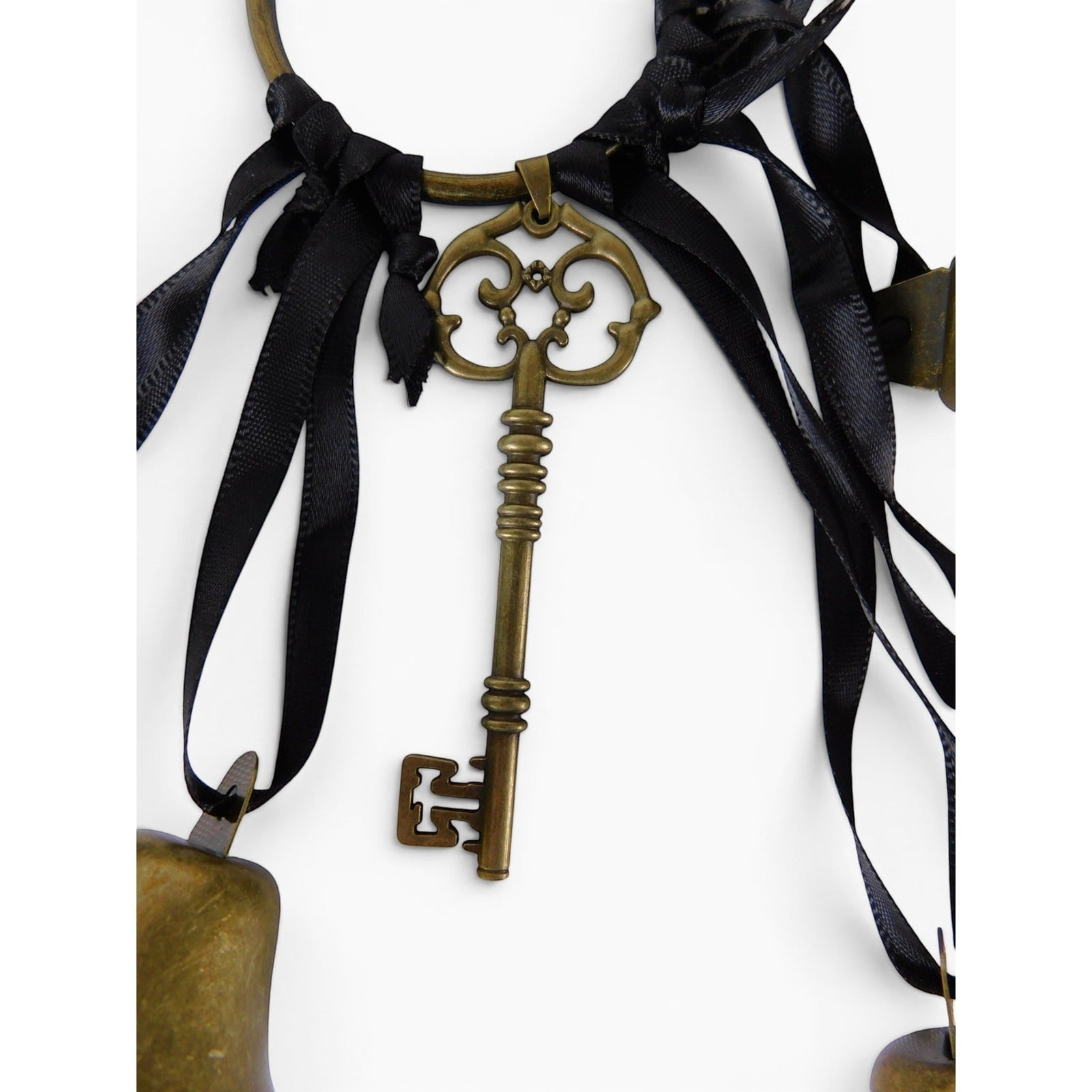 The Witches' Quest gold-tone metal skeleton key charm hanging from a circular ring with black ribbons and chime bells.