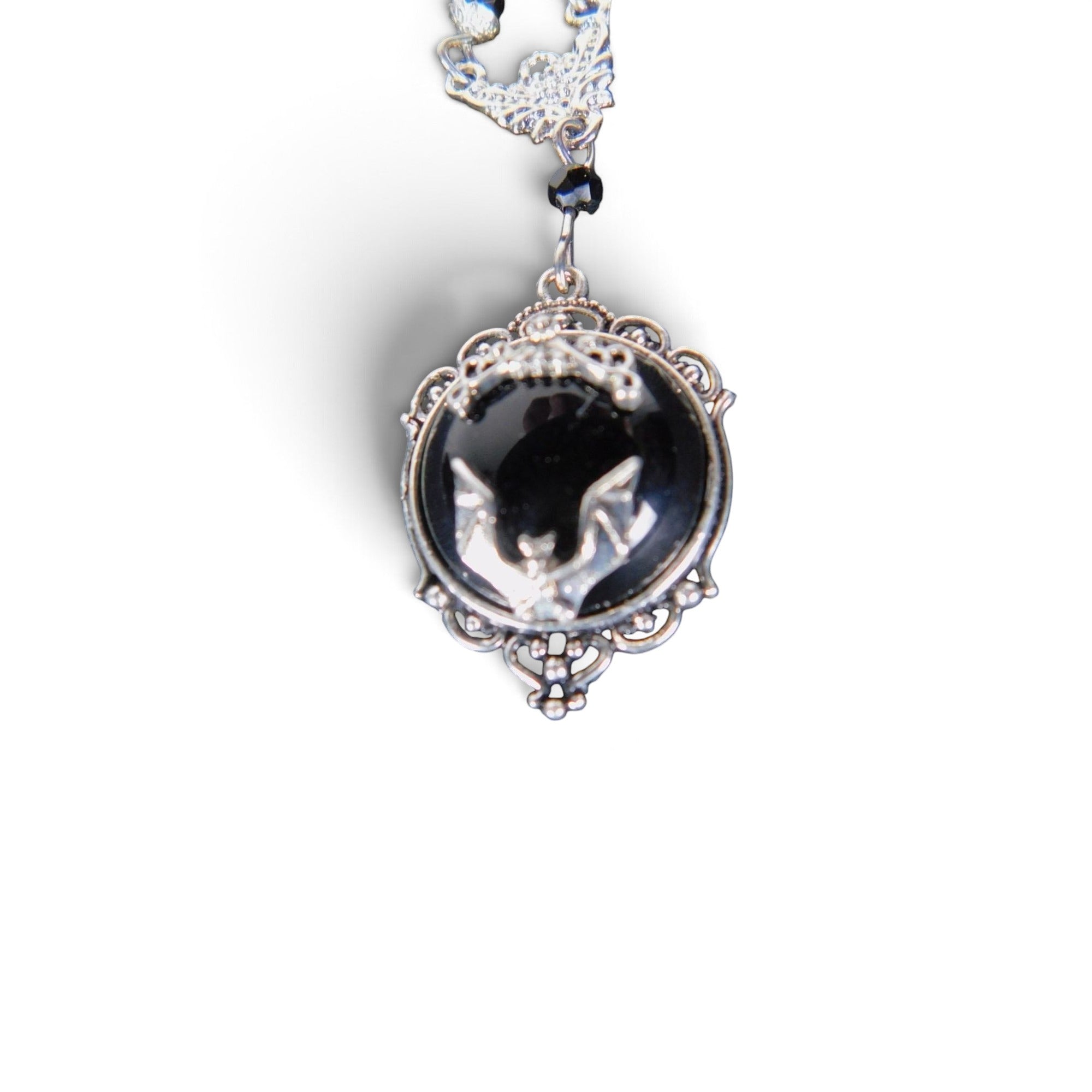The Witches' Quest Victorian gothic necklace with a silver bat cameo on a black resin background in an ornate frame.