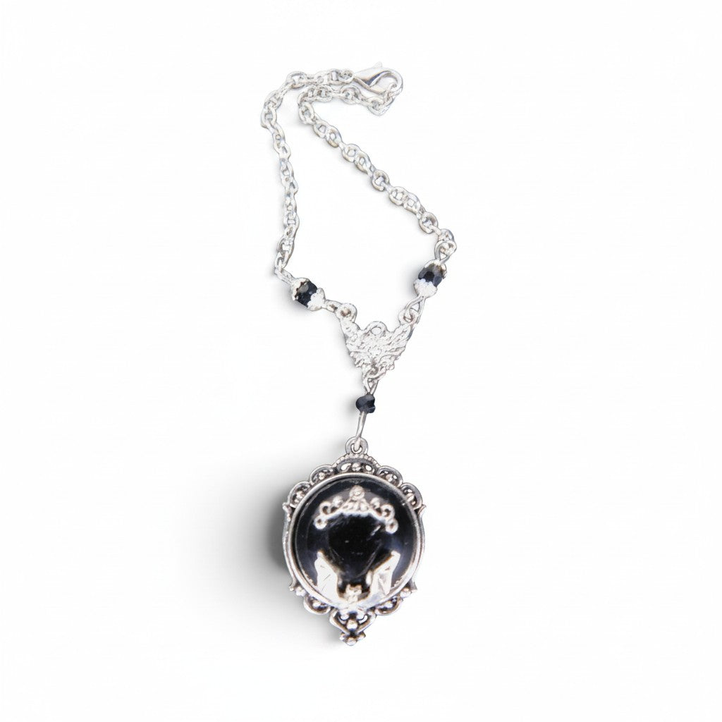 The Witches' Quest gothic bat cameo necklace in silver-tone alloy with a black resin backdrop and ornate scrollwork.