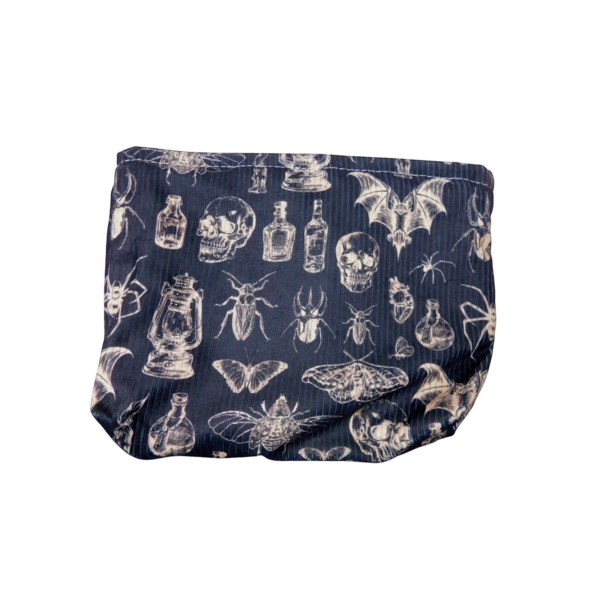 The Witches' Quest black gothic makeup bag featuring a white print of skulls, insects, bats, and vintage bottles.
