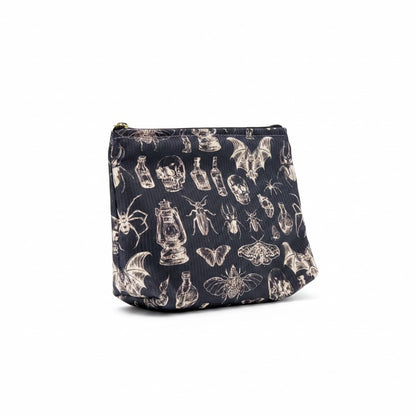 The Witches' Quest gothic makeup bag in black fabric with a white skull, insect, and lantern print and zipper closure.