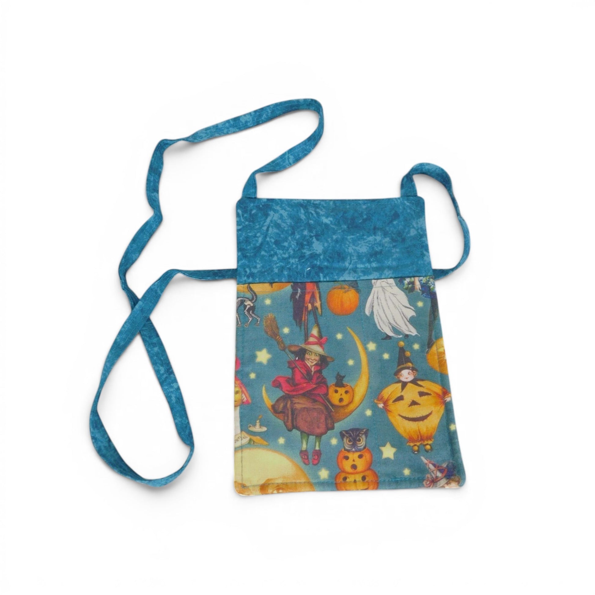 The Witches' Quest handmade Halloween crossbody bag with vintage witch and pumpkin print on a wooden table with leaves