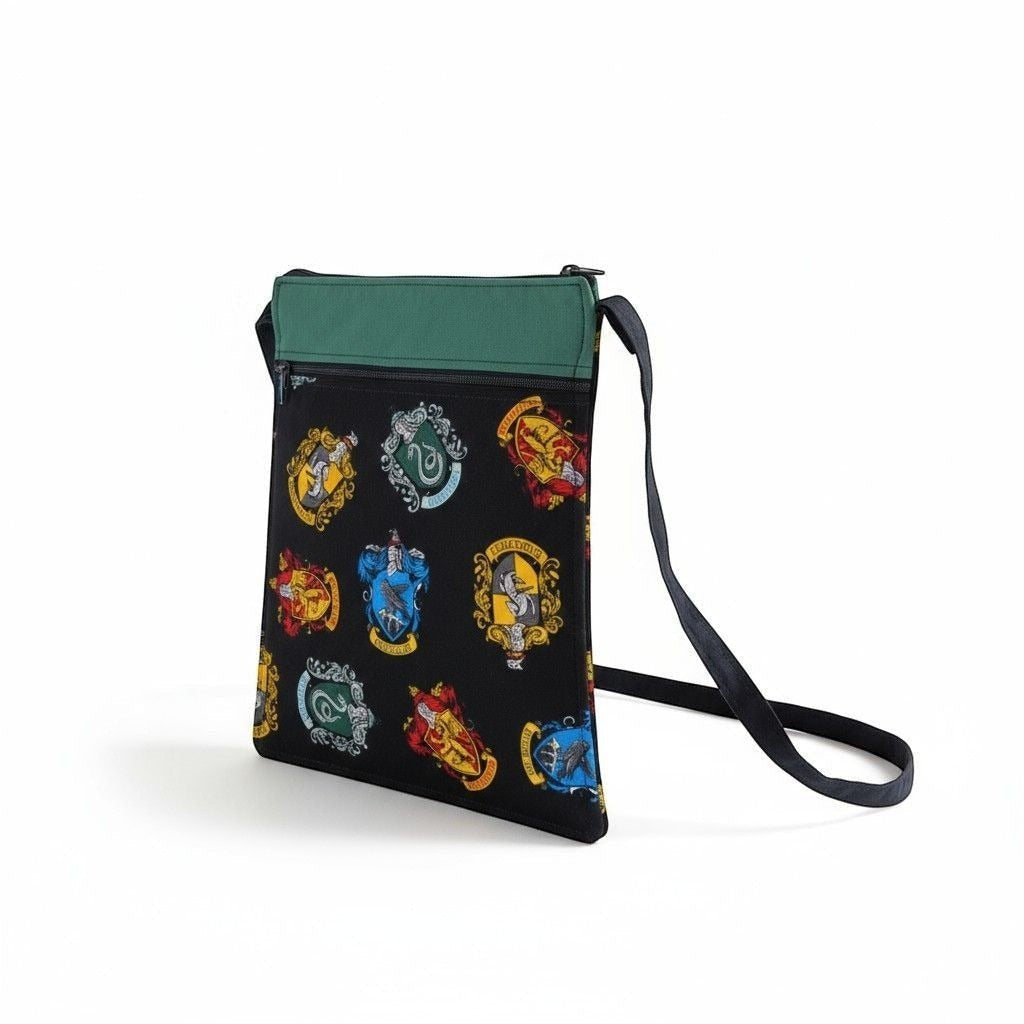 The Witches' Quest handcrafted Harry Potter crossbody bag with vibrant house crests on black fabric and green trim.