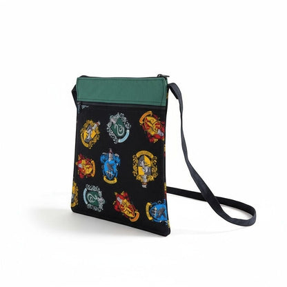 The Witches' Quest handcrafted Harry Potter crossbody bag with vibrant house crests on black fabric and green trim.