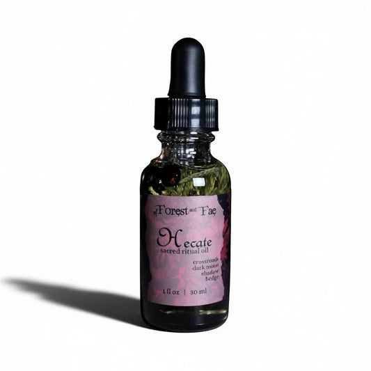 The Witches' Quest Hecate sacred ritual oil in a 1 fl oz glass dropper bottle with visible herbs inside.