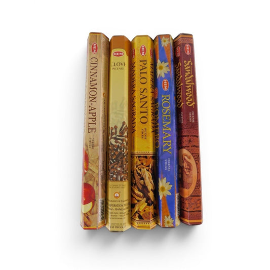 The Witches' Quest HEM incense variety pack featuring five hexagonal boxes of Cinnamon Apple, Clove, Palo Santo, Rosemary, and Sandalwood scents.