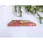 The Witches' Quest Herbal Goddess softcover book by Amy Jirsa lying flat on a white surface with green foliage