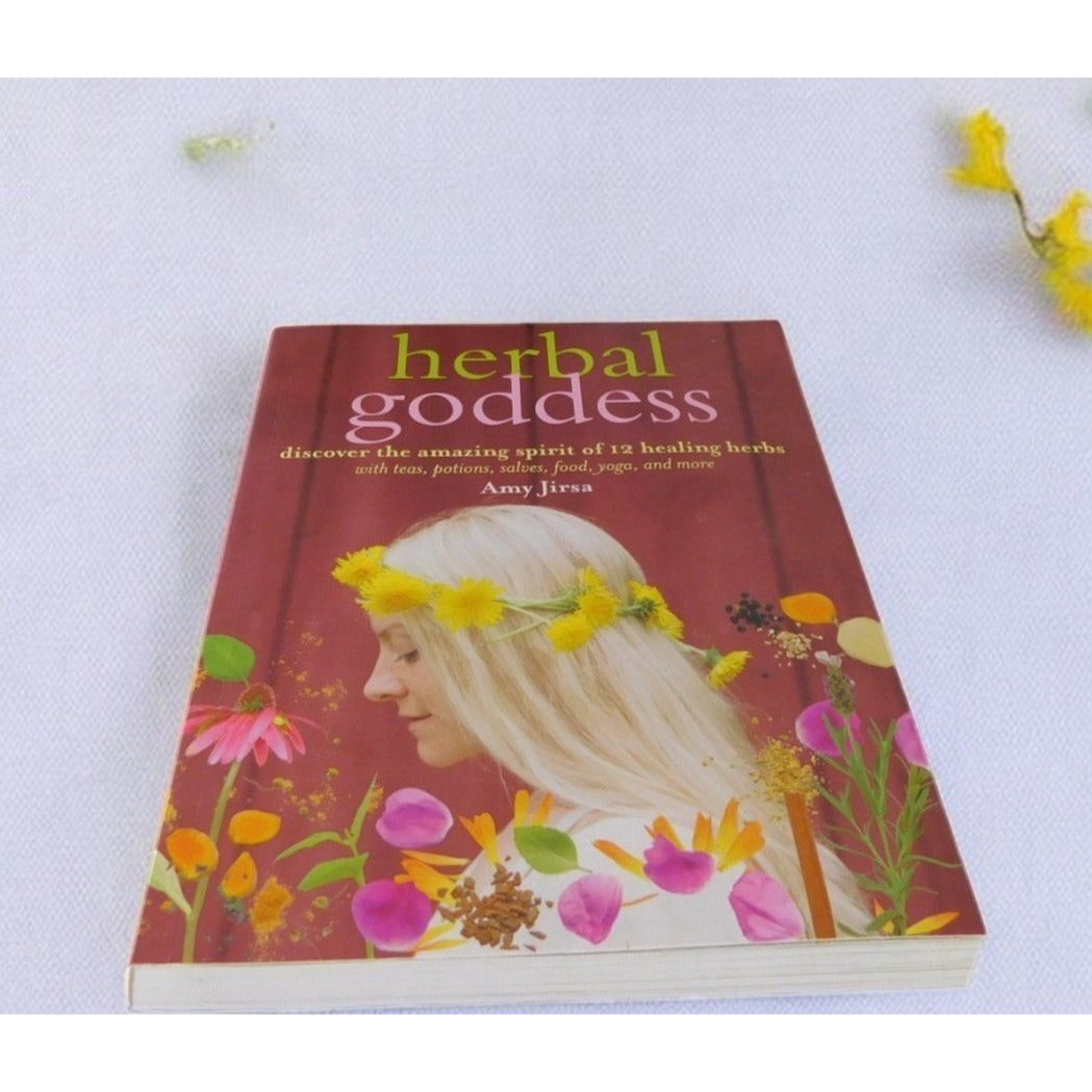 The Witches' Quest Herbal Goddess softcover book by Amy Jirsa featuring a woman with a yellow flower crown