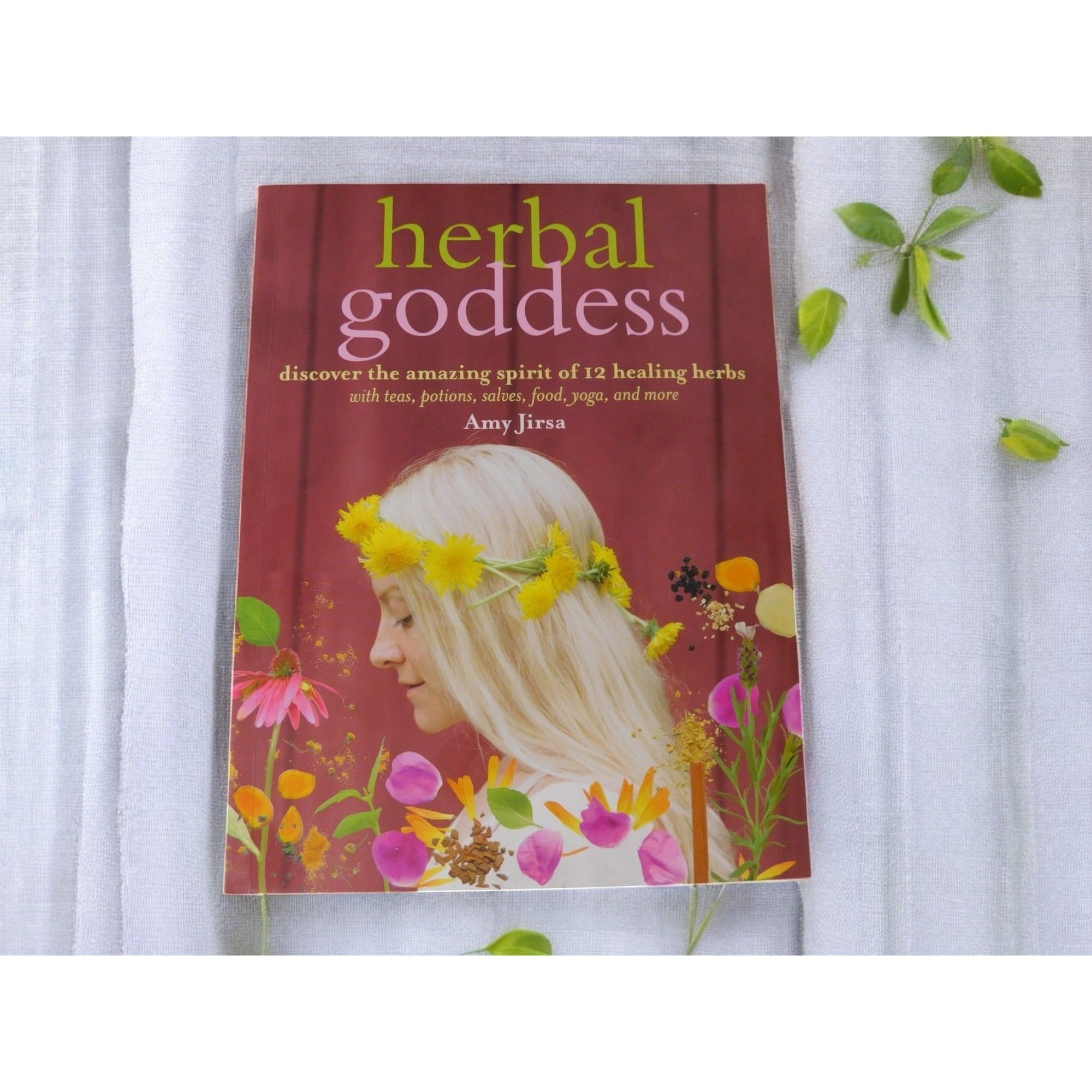 The Witches' Quest Herbal Goddess softcover book by Amy Jirsa featuring a woman with a flower crown on the cover.