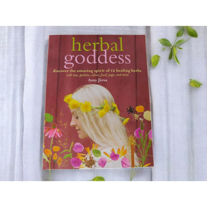 The Witches' Quest Herbal Goddess softcover book by Amy Jirsa featuring a woman with a flower crown on the cover.