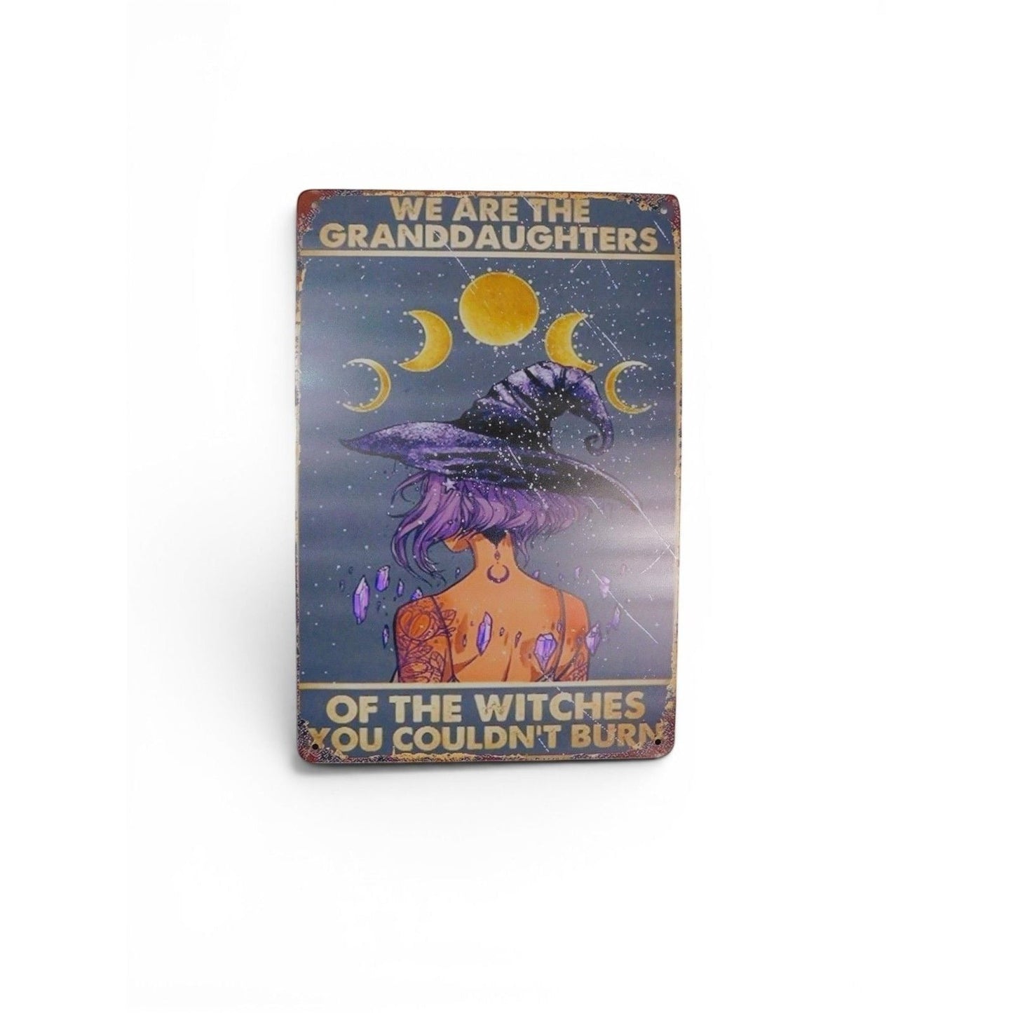 The Witches' Quest metal sign featuring a witch with purple hair, moon phases, and empowering text on a starry background