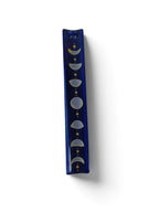 The Witches' Quest midnight blue ceramic incense stick holder with hand-painted moon phases and golden stars.