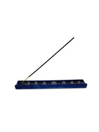 The Witches' Quest midnight blue ceramic incense holder featuring a hand-painted moon phase cycle and golden stars.