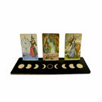 The Witches' Quest wooden moon phase tarot card display stand holding three oracle cards against a white background.