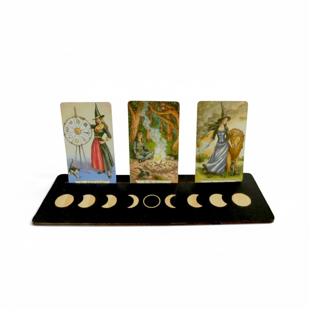 The Witches' Quest wooden moon phase tarot card display stand holding three oracle cards against a white background.