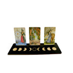 The Witches' Quest wooden moon phase tarot card display stand holding three oracle cards on a white background.