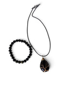 The Witches' Quest obsidian bead bracelet and wire-wrapped tree of life obsidian pendant necklace on a black cord.