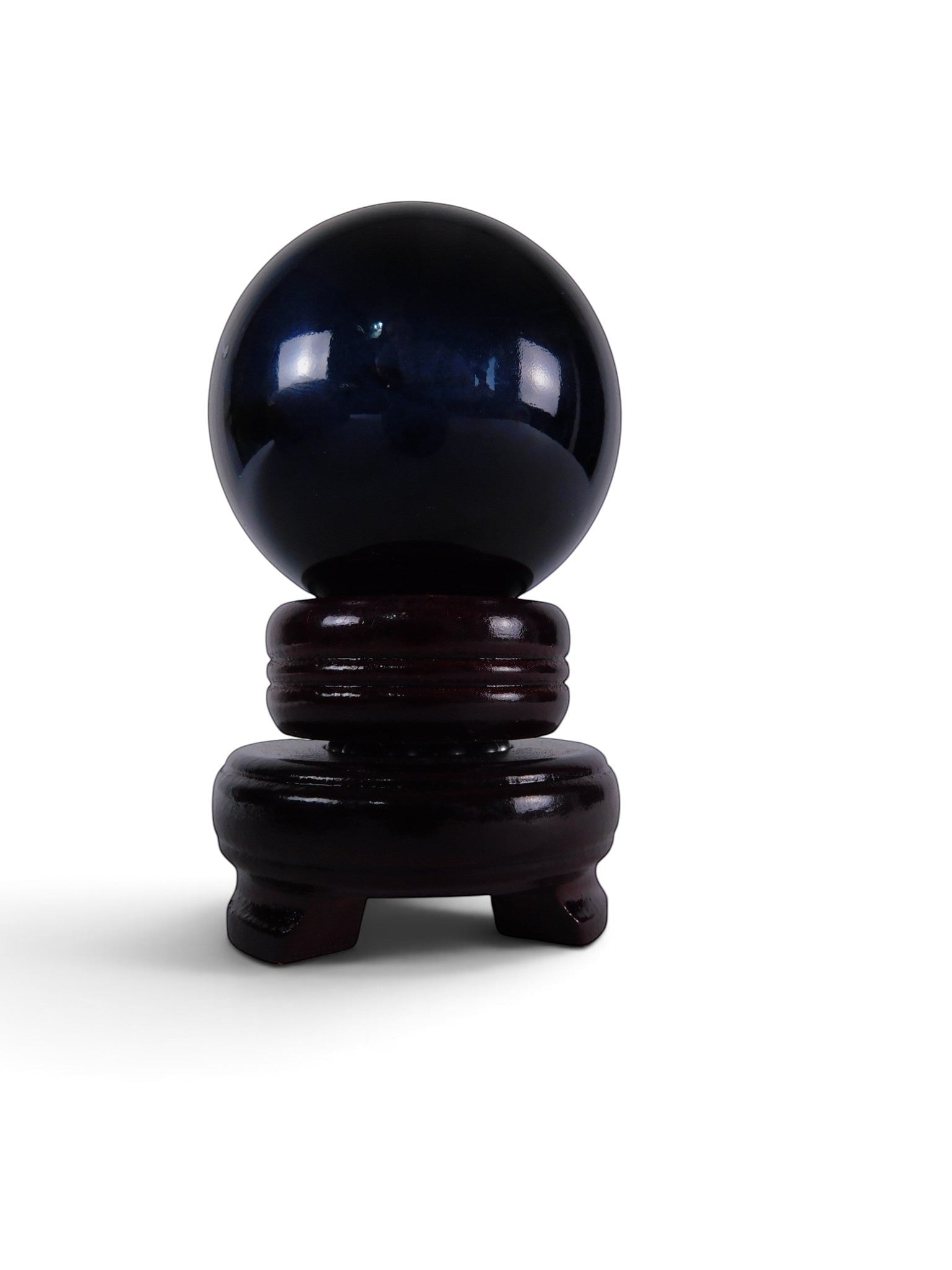 The Witches' Quest polished black obsidian crystal sphere resting on a dark wooden display stand
