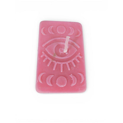 The Witches' Quest handmade pink rectangular candle with embossed mystical eye and moon phase celestial design.