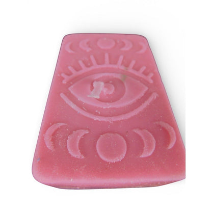 The Witches' Quest handmade pink rectangular wax candle with embossed mystical eye and moon phase celestial design.