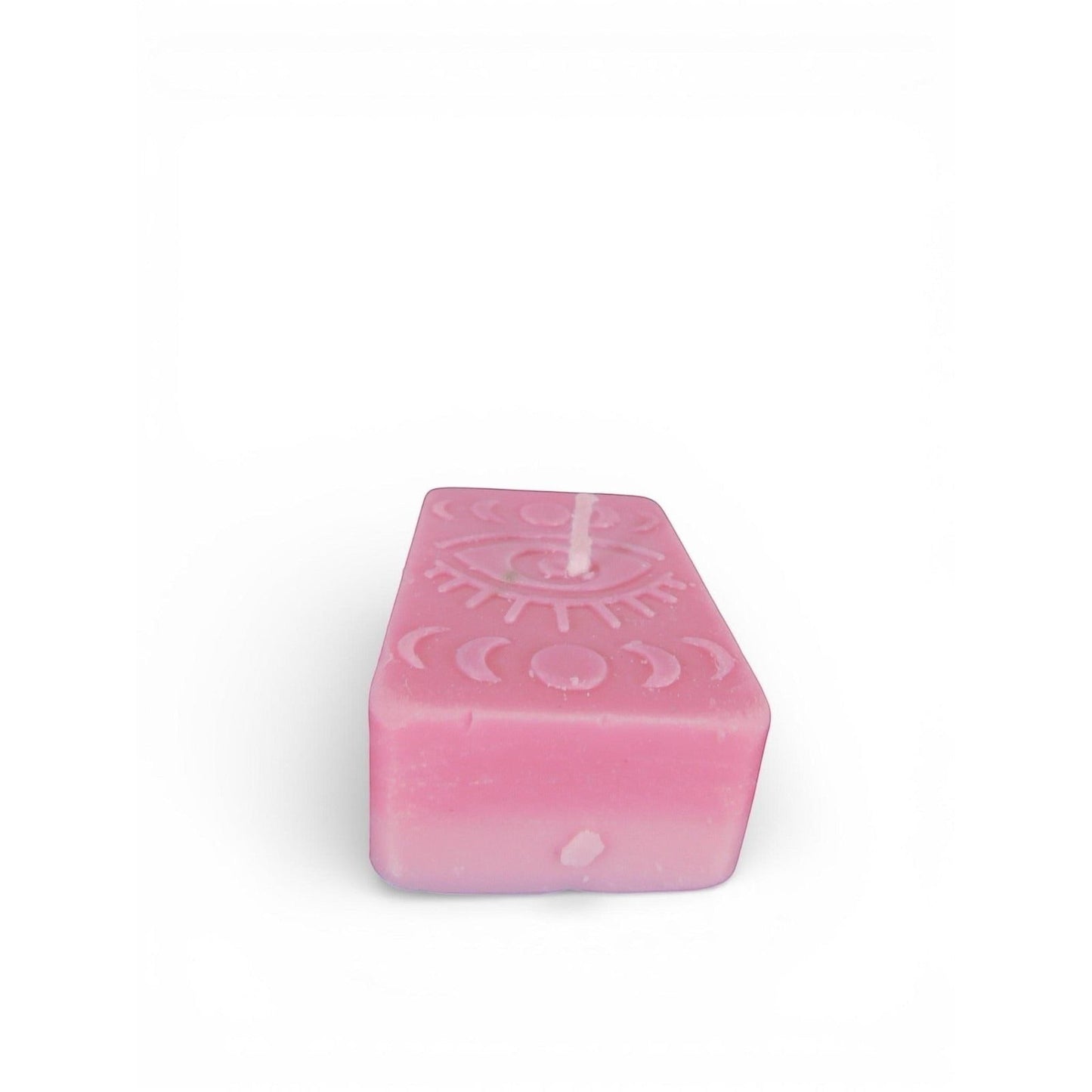 The Witches' Quest pink rectangular wax candle featuring an embossed mystical eye and moon phase design.