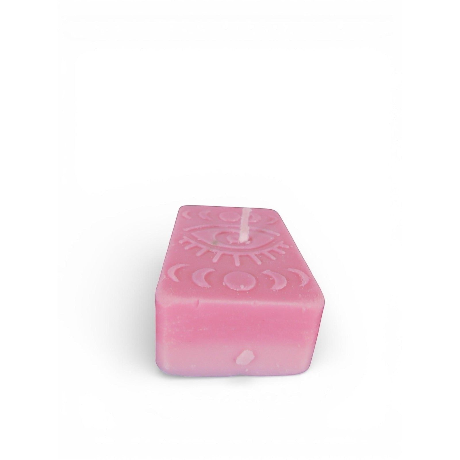 The Witches' Quest pink rectangular wax candle featuring an embossed mystical eye and moon phase design.