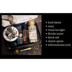 The Witches' Quest protection travel altar kit in a black tin with ritual tea light, herbs, onyx, and Florida water.