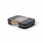 The Witches' Quest Protection Travel Altar Kit in a black metal tin with a skull-themed label on a white background.