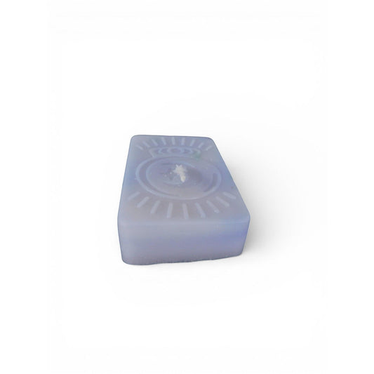 The Witches' Quest handmade purple rectangular wax candle with an embossed celestial moon and sun ray emblem.