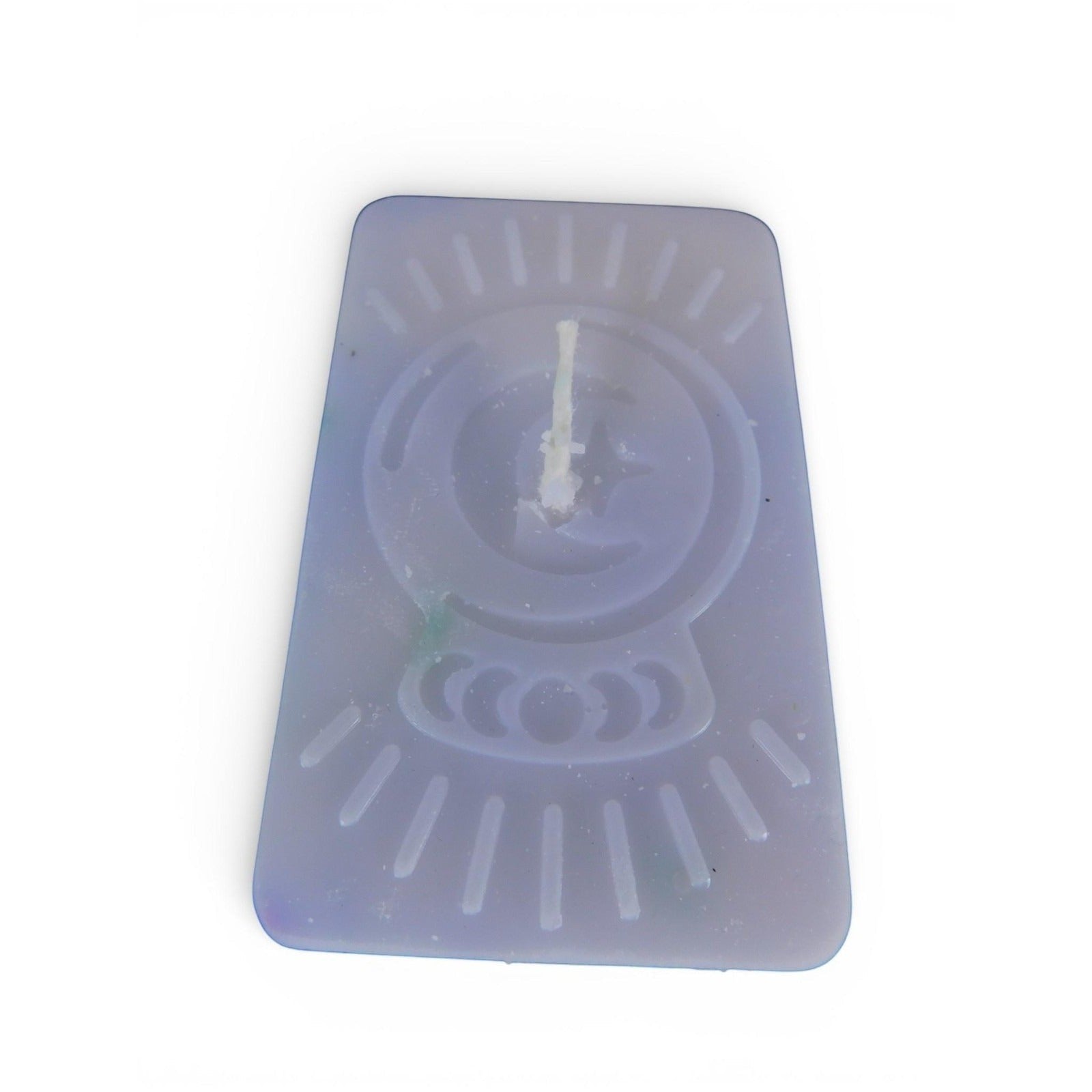 The Witches' Quest purple rectangular wax candle with an embossed celestial moon and sun ray design for altar decor.