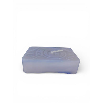 The Witches' Quest purple rectangular wax candle with an embossed celestial moon and sun ray emblem for altar decor.