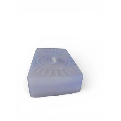 The Witches' Quest handmade purple rectangular wax candle with an embossed celestial moon and sun ray emblem.