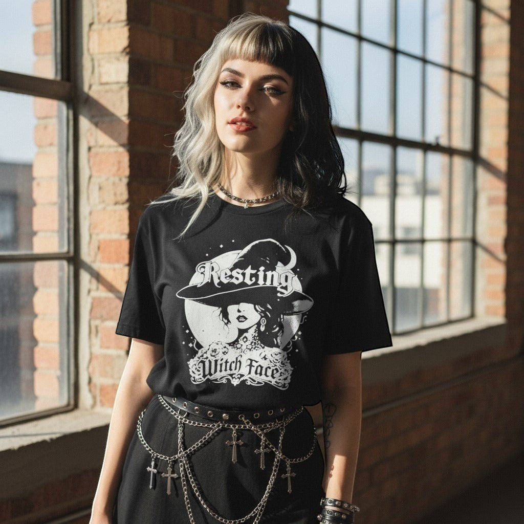The Witches' Quest black cotton crew neck t-shirt with a white Resting Witch Face graphic worn by a woman
