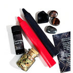 The Witches' Quest Return to Sender ritual kit with red and black candles, uncrossing oil, herb blend, and crystals.