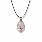 The Witches' Quest rose quartz teardrop pendant necklace with a copper wire wrapped tree of life design on a black cord
