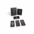The Witches' Quest The Sacred Web tarot deck and guidebook set featuring dark charcoal cards with cosmic artwork.