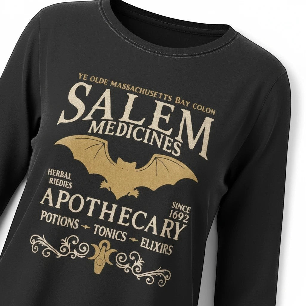 The Witches' Quest black long sleeve crewneck shirt with a gold Salem Apothecary bat and vintage medicine graphic.