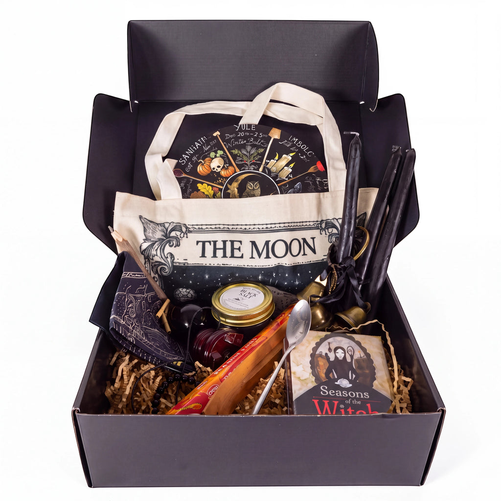 The Witches' Quest Samhain altar bundle in a black box featuring an oracle deck, obsidian, candles, and moon tote bag.