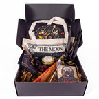 The Witches' Quest Samhain altar bundle in a black box featuring an oracle deck, obsidian, candles, and moon tote bag.