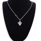 The Witches' Quest silver-tone cross locket necklace with intricate floral filigree and a magnetic secret compartment.