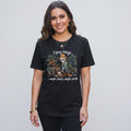 A woman wearing a black The Witches' Quest cotton t-shirt with a skeleton gardener graphic and humorous text.