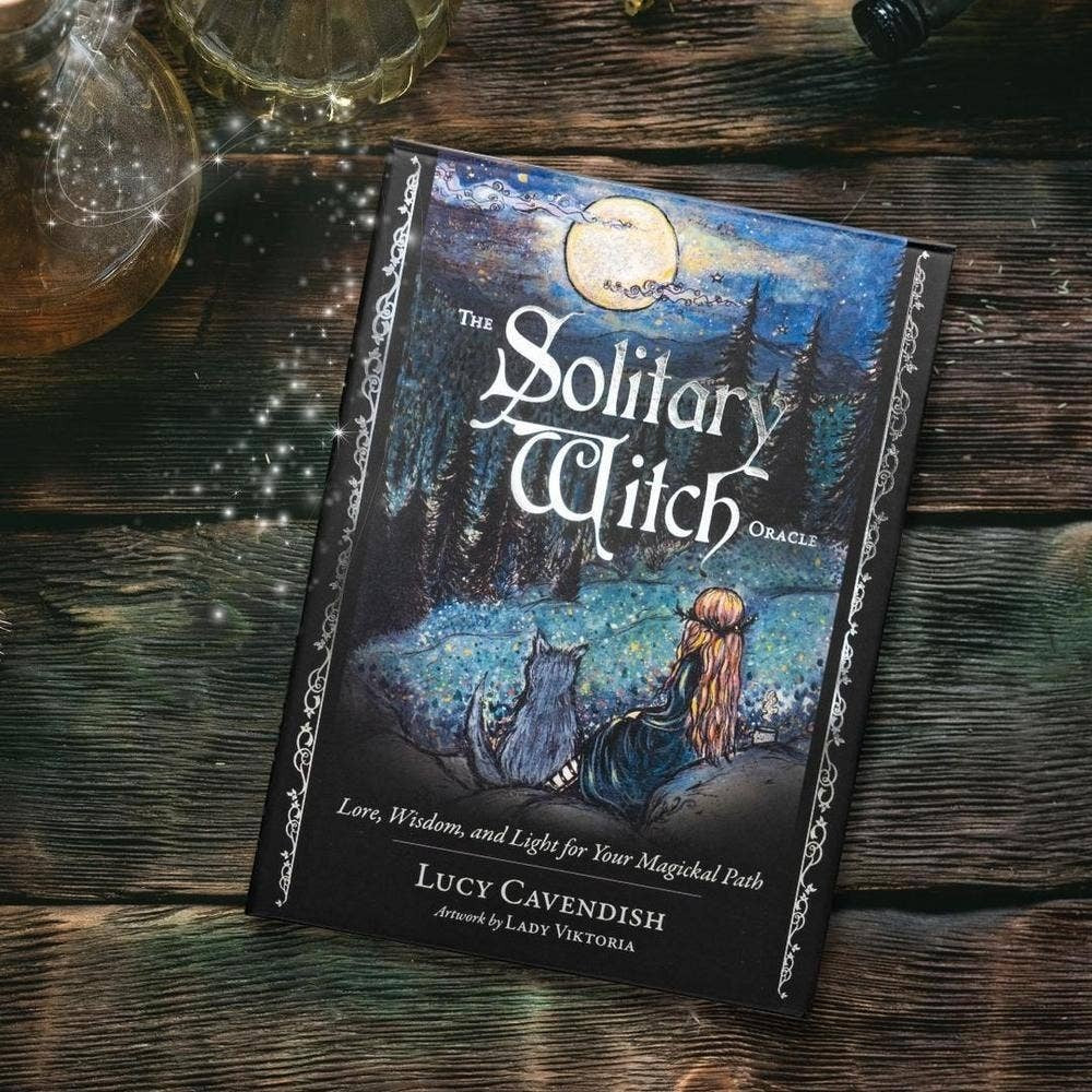 The Solitary Witch Oracle deck by The Witches' Quest featuring ethereal forest artwork with a witch and cat