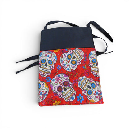 The Witches' Quest handcrafted crossbody bag featuring a vibrant red sugar skull pattern and black adjustable strap.