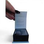 The Witches' Quest Taurus zodiac crystal stone pack featuring clear and rose quartz in a gift box held by a hand.