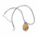 The Witches' Quest Tiger's Eye teardrop pendant with wire-wrapped Tree of Life design on a black cord necklace.