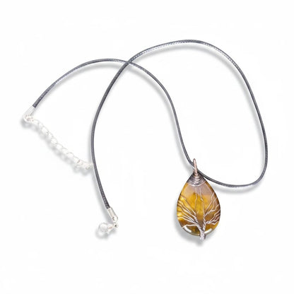 The Witches' Quest Tiger's Eye teardrop pendant with a wire-wrapped Tree of Life design on a black cord necklace.